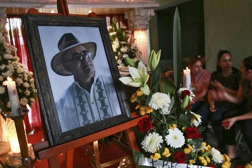 Relatives keeping vigil over the candidate for Yurecuaro mayor Enrique Hernandez (in the portrait) during his funeral chapel at his home in Yurecuaro, in the state of Michoacan, Mexico, on May 15, 2015.&nbsp;A town police chief in Mexico is allegedly