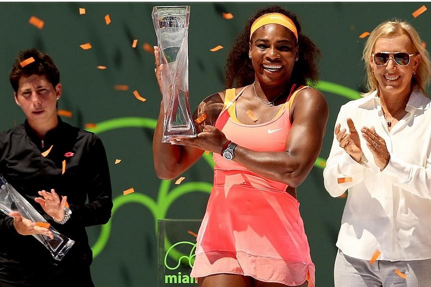 Flanked by Carla Suarez Navarro of Spain and Martina Navratilova, Serena Williams poses with the Butch Buchholz Trophy after defeating Navarro during the final on day 13 of the Miami Open Presented by Itau at Crandon Park Tennis Center on April 4, 20