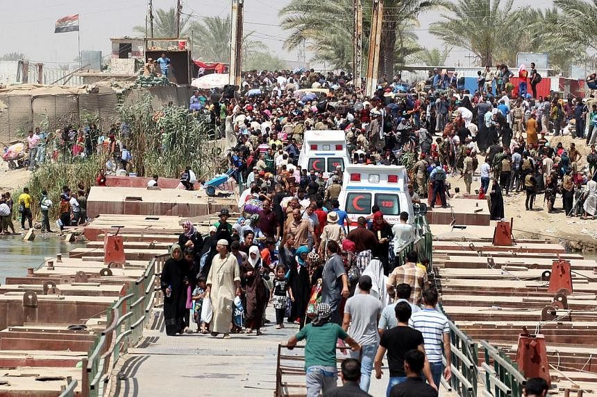 Iraqi residents from the city of Ramadi, who fled their homes as Islamic State militants tightened their siege on the last government positions in the capital of Anbar province, wait to cross Bzeibez bridge, on the southwestern frontier of Baghdad, o