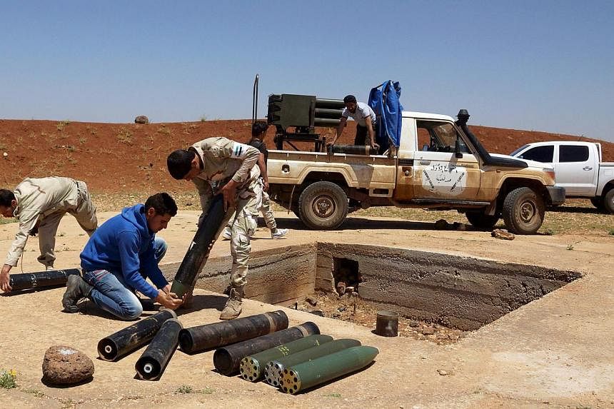 Free Syrian Army fighters prepare shells prior to firing towards forces loyal to Syria's President Bashar al-Assad in Izra'a in the Deraa countryside on May 21, 2015. At least 40 rebels were killed as a regime air strike on their base in the northern