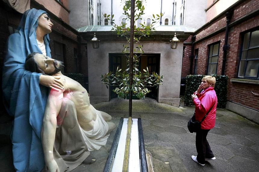 A woman prays in front of a statue of Mary and Jesus in the Grafton street area of Dublin in Ireland May 19, 2015. -- PHOTO: REUTERS