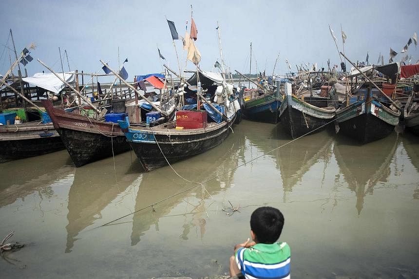 An ethnic Rohingya Muslim child looks at boats near a jetty at a refugee camp outside the city of Sittwe in Myanmar's Rakhine state on May 22, 2015. -- PHOTO: AFP
