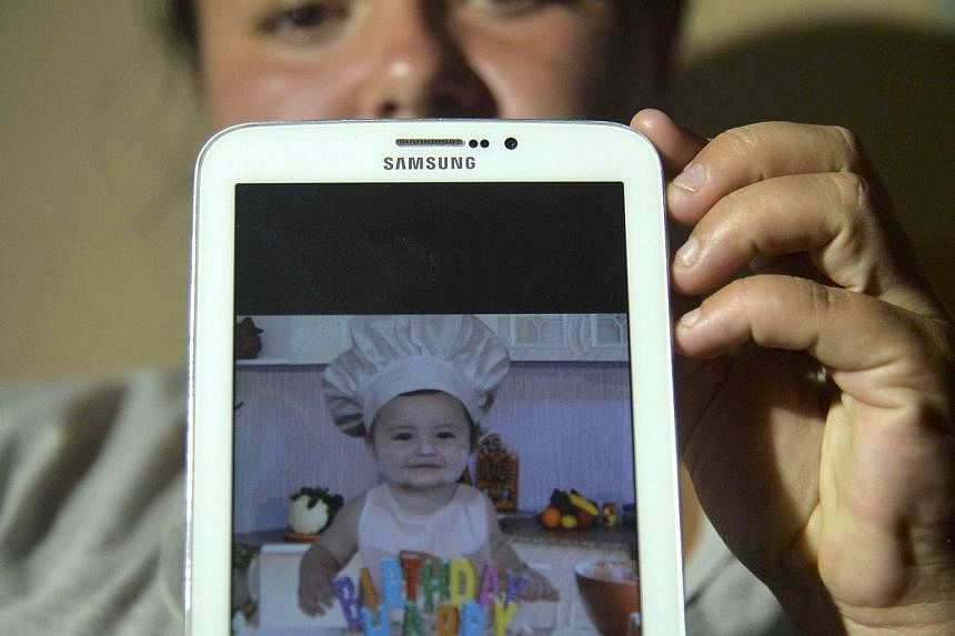 Colombian Natalia Rincon shows a picture on May 20, 2015, of baby Jhoset Diaz, who survived a massive landslide that tore through a ravine in north-west Colombia on Monday before dawn, killing at least 83 people and injuring 40. -- PHOTO: AFP&nbsp;