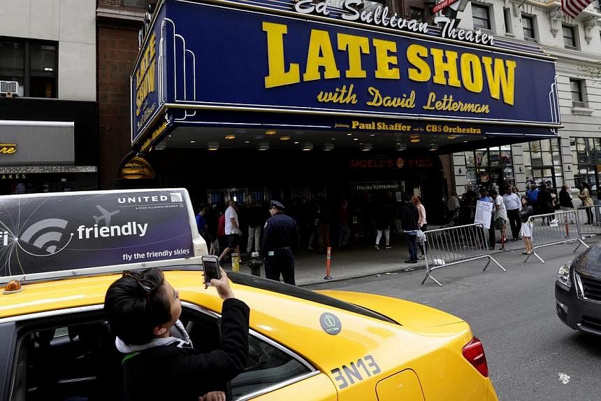 A woman takes a picture of the Ed Sullivan Theatre displaying the Late Show with David Letterman marquee, in New York, New York, USA, 20 May 2015. -- PHOTO: EPA