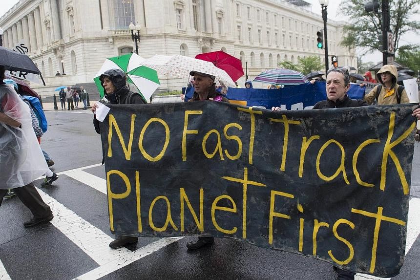 Demonstrators protest against the legislation to give US President Barack Obama fast-track authority to advance trade deals, including the Trans-Pacific Partnership, during a protest march on Capitol Hill in Washington, DC, May 21, 2015. -- PHOTO: AF