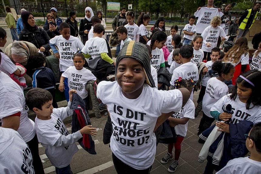 Primary school pupils in Amsterdam wearing T-shirts with the slogan: "Is this white enough for you?" preparing to distribute leaflets in Amsterdam on May 22, 2015. -- PHOTO: EPA&nbsp;