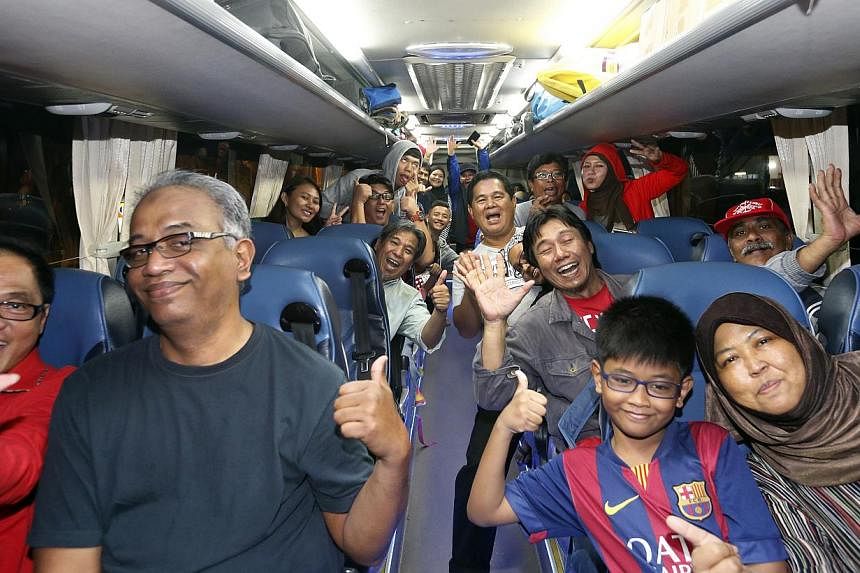 Some of the 3,000 LionsXII supporters cheering yesterday as they were about to leave for Kuala Lumpur for tonight's Malaysian FA Cup final, the first for the Singapore club.