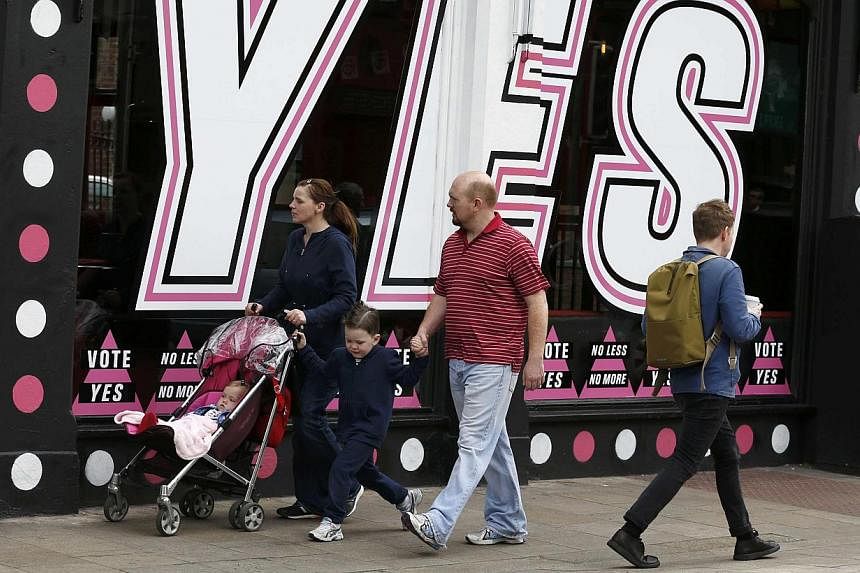 A family walk past a window decorated in favour of same sex marriage in central Dublin as Ireland holds a referendum on gay marriage, May 22, 2015. -- PHOTO: REUTERS