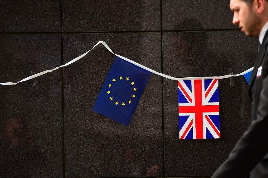An European flag and a British flag stand next to each other outside the European Commission building in Brussels on May 8 2015. Britain's centre-left opposition Labour party will support Prime Minister David Cameron's proposal for a referendum on Eu