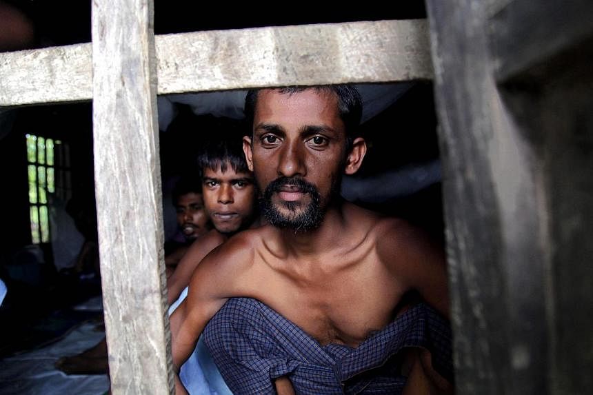 Rohingya Muslims from Banglades, rescued by the Myanmar navy, sit inside buildings at a temporary refugee camp in the village of Aletankyaw in the Maungdaw township of northern Rakhine state, Myanmar, on May 23, 2015. -- PHOTO: EPA