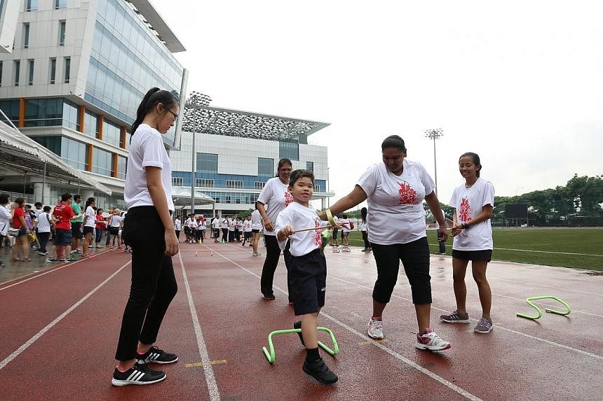 Maximus Lee How Zer, seven, from MINDS Woodlands Gardens School playing the Ketupat Race during a sports event to mark Singapore's golden jubilee at the&nbsp;Institute of Technical Education College Central on May 23, 2015. He is being cheered on by 