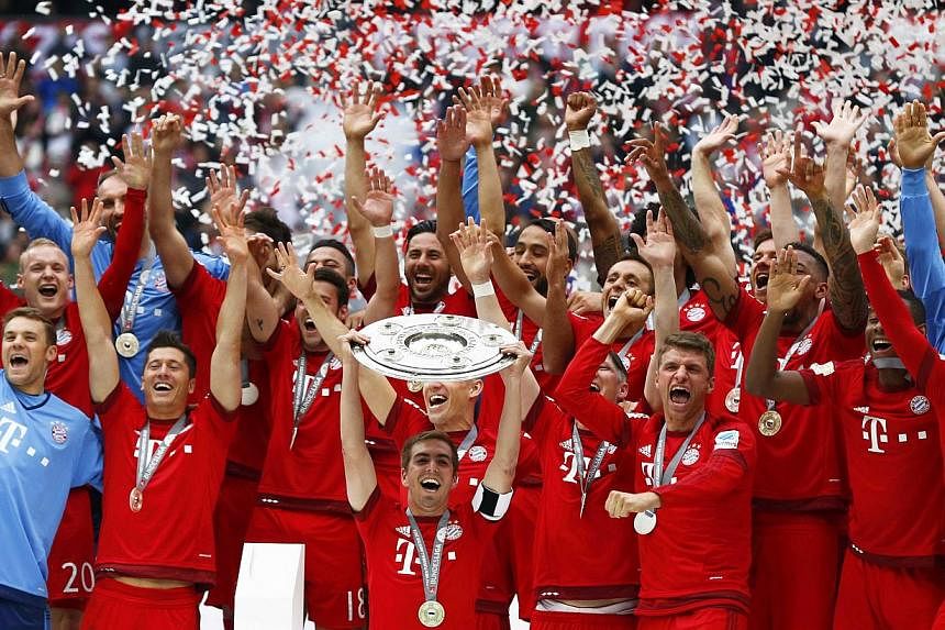 Bayern Munich's Philipp Lahm lifts up the trophy after their final Bundesliga match of the season against Mainz in Munich, on May 23, 2015. -- PHOTO: REUTERS