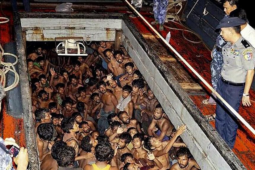 A handout photo provided by the Myanmar Information Ministry shows Myanmar police officers on a fishing boat with migrants, most of them from Bangladesh, according to a government website,&nbsp;near the coast of Rakhine, Myanmar on May 22, 2015. -- P