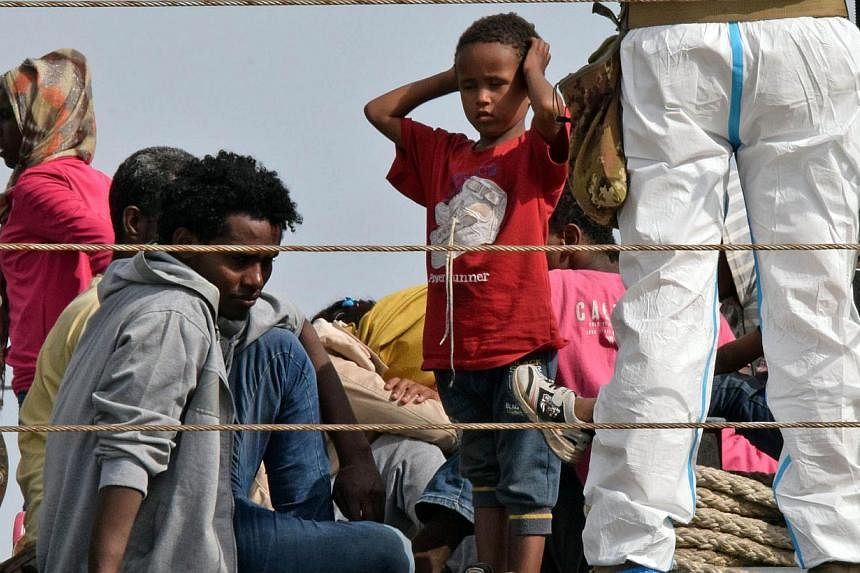 Migrants waiting to disembark from the Italian military ship "Sfinge" as they arrived in the port of Augusta, on the eastern coast of Sicily on May 21, 2015. The Italian Coast Guard said that&nbsp;Seventy Afghan and Iraqi migrants were rescued from a