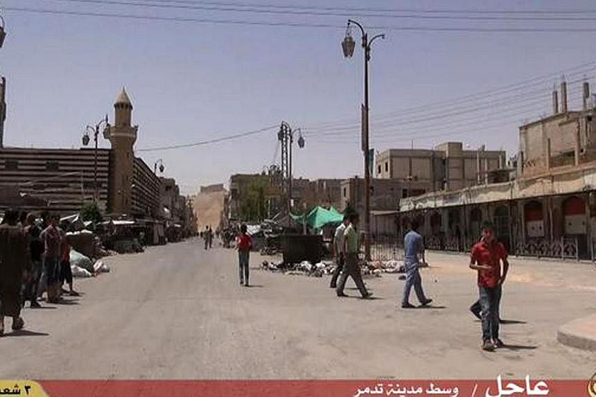 An image grab taken from a video made available by Jihadist media outlet Welayat Homs on May 21, 2015 allegedly shows people walking in a street of Syria's ancient city of Palmyra after the Islamic State in Iraq and Syria (ISIS) seized it. -- PHOTO: 