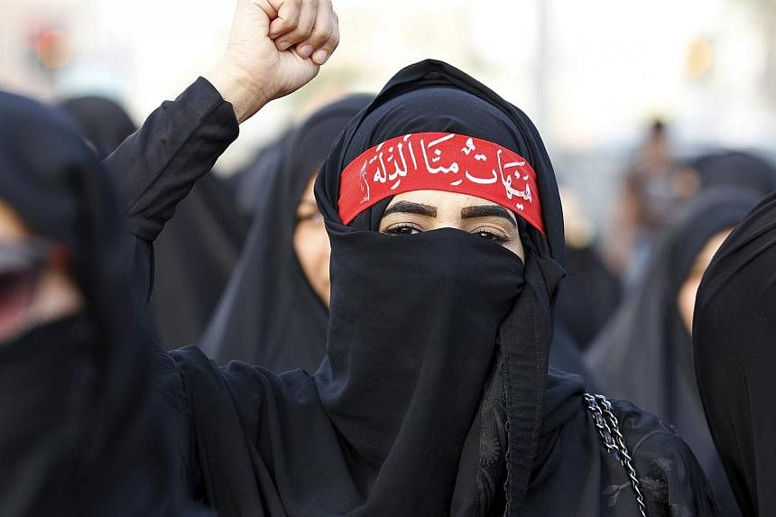 A protester shouts pro-Shi'ite slogans as she marches in the village of Sanabis, west of Manama, Bahrain, to show solidarity for victims of a suicide bomb attack in Saudi Arabia, May 23, 2015. -- PHOTO: REUTERS