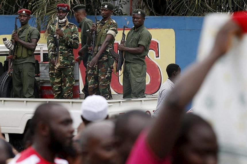 Soldiers stand as mourners carry the casket of Zedi Feruzi, the head of opposition party UPD, in Bujumbura, Burundi, on May 24, 2015. -- PHOTO: REUTERS