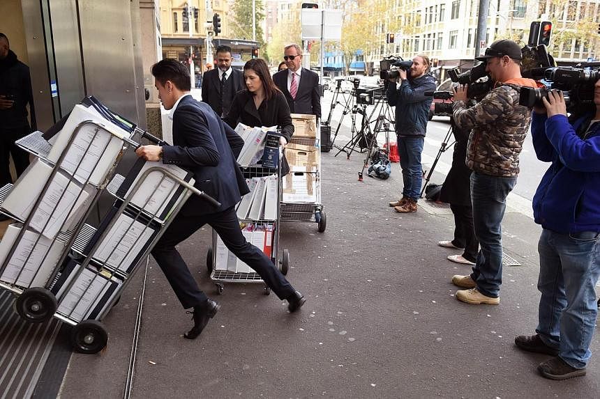 Television crews (right) film people entering the building in Sydney on May 25, 2015, where an inquest into the deaths arising from the Lindt Café siege is being held. -- PHOTO: AFP&nbsp;