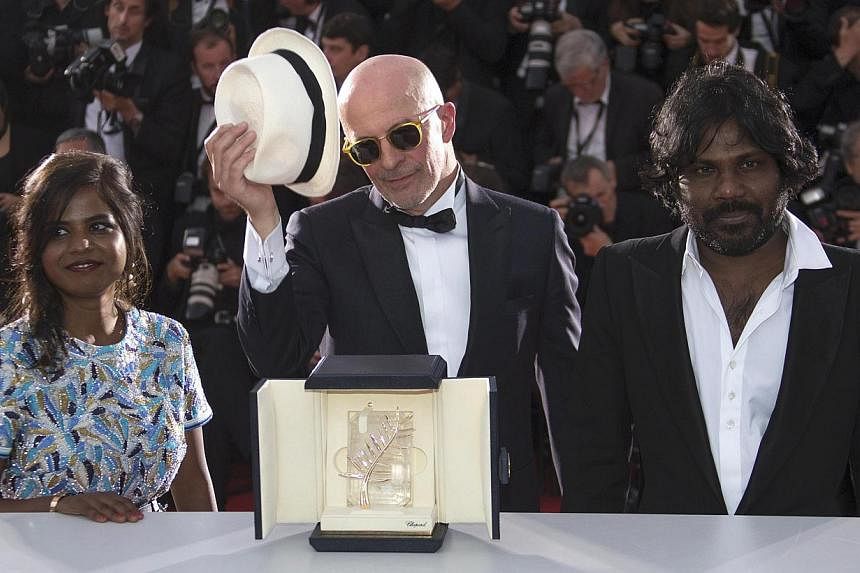 Director Jacques Audiard (centre), Palme d'Or award winner for his film Dheepan, actress Kalieaswari Srinivasan (left) and actor Jesuthasan Antonythasan pose during a photocall after the closing ceremony of the 68th Cannes Film Festival in southern F