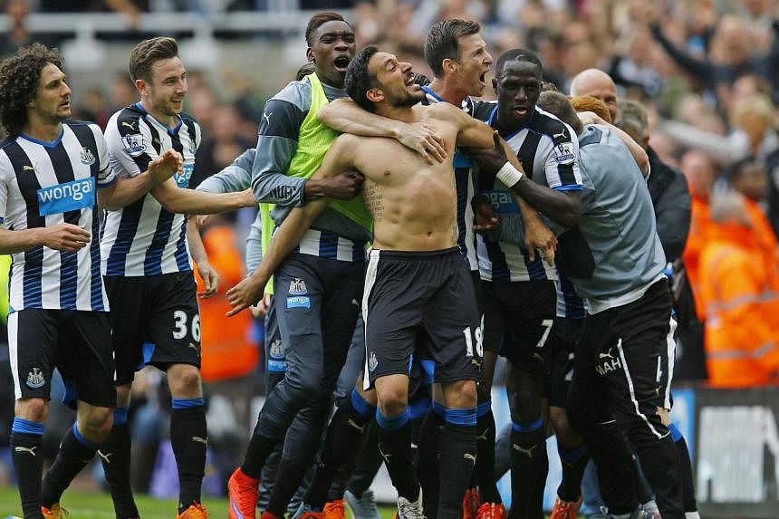 Jonas Gutierrez (centre, without shirt) celebrates with manager John Carver (right, in grey) and team mates after scoring the second goal for Newcastle United. -- PHOTO: REUTERS