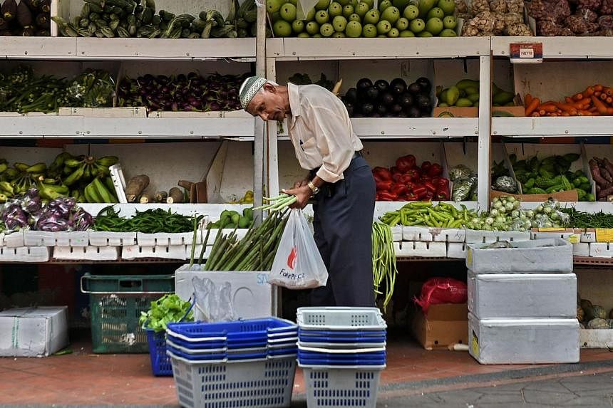 A man shops for vegetables at a market in Singapore on May 8, 2015. -- PHOTO: AFP