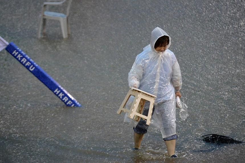 An official crossing a water-logged field during the Asia Rugby Championship game between Hong Kong and Japan in Hong Kong last Saturday. The match was cancelled due to heavy rain and thunderstorms.