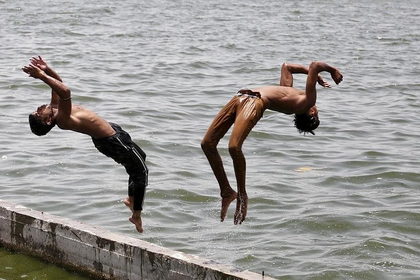 Boys jumping into the Sabarmati river in Ahmedabad yesterday to cool off. Temperatures in the city yesterday reached 43 deg C, according to the India Meteorological Department website. -- PHOTO: EUROPEAN PRESSPHOTO AGENCY