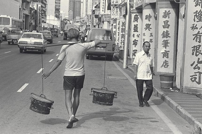 A night-soil worker carrying buckets of night soil to a waiting truck in North Bridge Road during Singapore's earlier years. Back then, diarrhoea was widespread and outbreaks of typhoid fever were common.