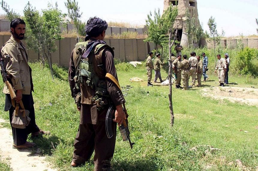 Afghan militias and policemen gather as they discuss during a battle against Taleban militants at the Chardara district of Kunduz province, May 3, 2015. About 40 people were wounded on Monday when a Taleban suicide bomber detonated a truck carrying a