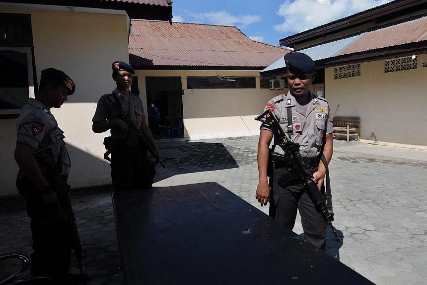Indonesian police officers stand guard outside a mortuary where the two bodies of suspected islamic militants are stored at a police hospital in Palu, Central Sulawesi, Indonesia, on May 25, 2015. -- PHOTO: EPA