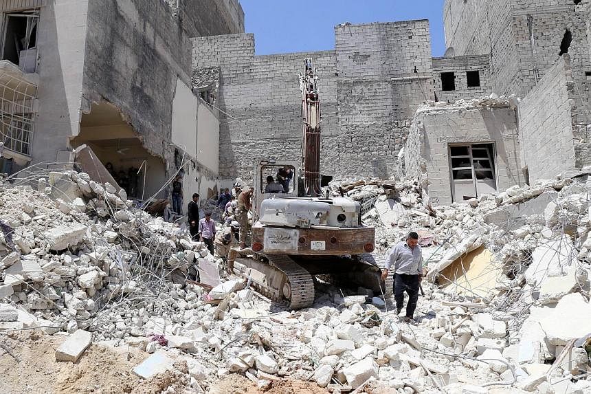 People inspect the rubble of collapsed buildings following a reported airstrike by government forces on May 24, 2015, in the rebel-held al-Sukari neighborhood of the northern city of Aleppo. Home Minister Datuk Seri Dr Ahmad Zahid Hamidi reassured Ma