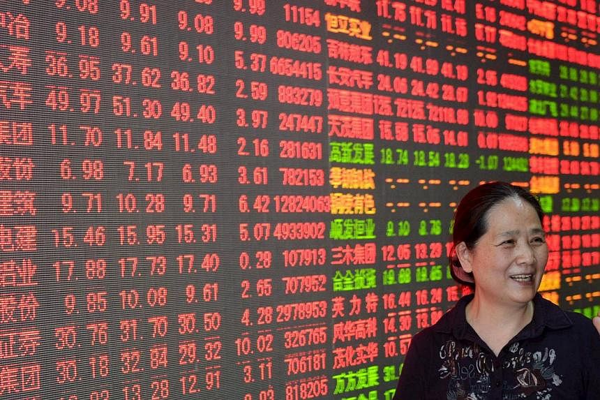 An investor gestures in front of a screen showing stock information at a brokerage house in Hangzhou, Zhejiang province, China, May 22, 2015. China stocks jumped to fresh seven-year highs on Monday morning, led by infrastructure and transport stocks,