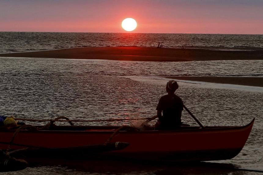 A fisherman watches the sunset in the South China Sea, about 130 nautical miles from Scarborough Shoal in the coastal town of Masinloc, Zambales in northern Philippines on April 21, 2015. -- PHOTO: REUTERS&nbsp;