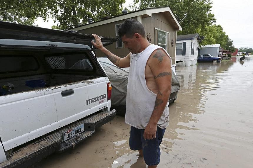 San Marcos resident Keith Varela checks out the damage done to his wife's truck in the San Marcos Mobile Home Park in San Marcos, Texas, on May 24, 2015.&nbsp;Rescuers searched on Monday, May 25, for at least 12 people missing in spectacular flash fl