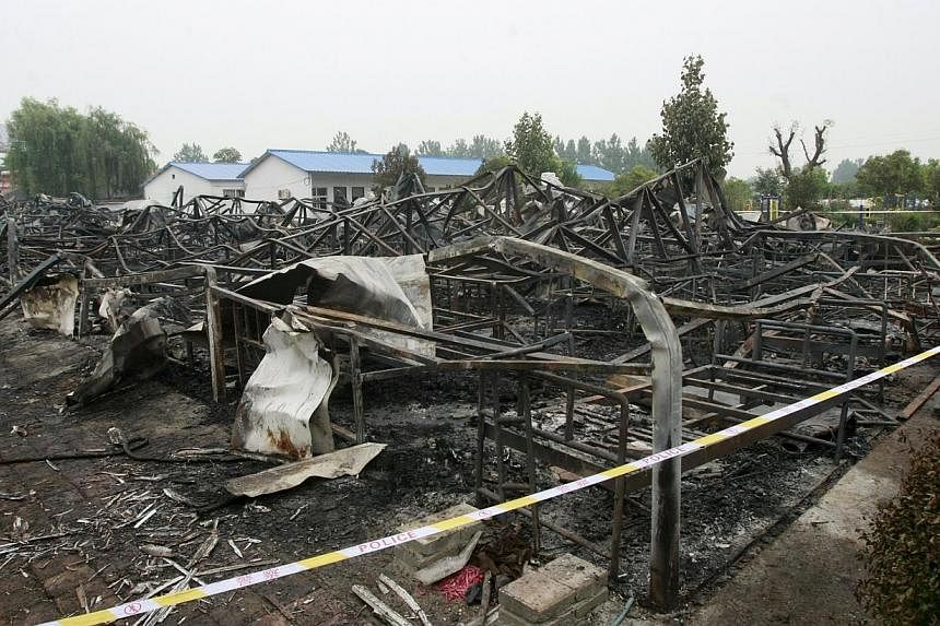 A general view shows the debris after a fire at a rehabilitation centre for the elderly in Sanlihe village of Pingdingshan, Henan province, China, on May 26, 2015. -- PHOTO: REUTERS