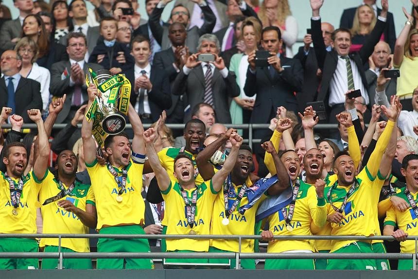 Norwich City's Russell Martin lifts the trophy as they celebrate gaining promotion to the Barclays Premier League &nbsp;after beating Middlesbrough 2-0 in the Championship play-off final at Wembley Stadium. -- PHOTO: REUTERS