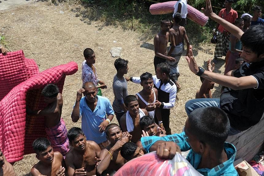 Bangladeshi migrants receiving mats at a shelter at Langsa in Indonesia's Aceh province on May 24, 2015.