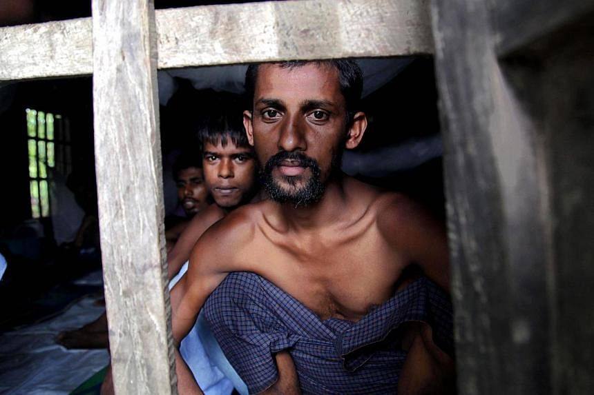 Rohingya Muslims from Bangladesh rescued by the Myanmar navy sit inside buildings at a temorary refugee camp in the village of Aletankyaw in the Maungdaw township of northern Rakhine state, Myanmar, on May 23, 2015. -- PHOTO: EPA&nbsp;