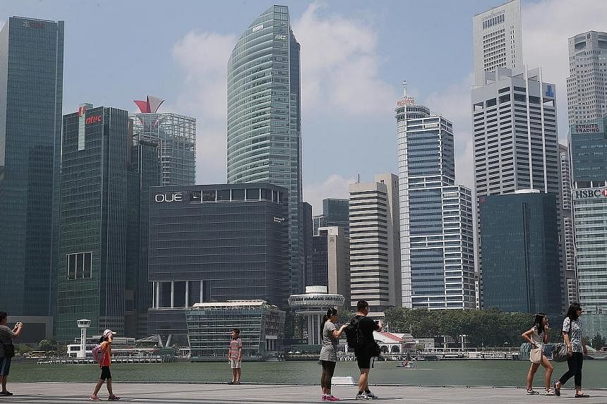 Tourists walking along the path on the waterfront promenade, along Marina Bay Sands as the skyline of Singapore Central Business District (CBD) stands in the background. The Singapore economy grew a moderate 2.6 per cent in the first three months of 