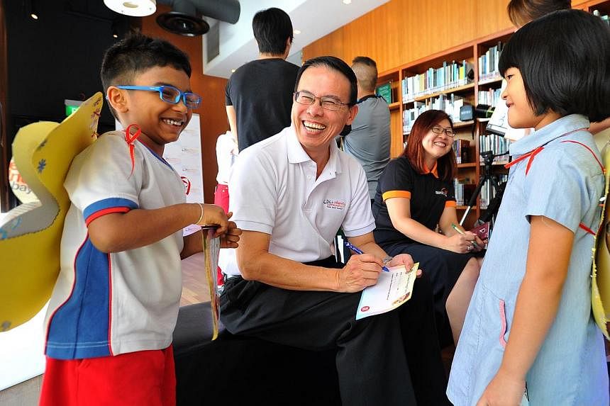Mayor for North West CDC Dr Teo Ho Pin (centre) writing Go Green Pledge Cards with children from PCF Sparkletots Woodlands during a media preview of CDCs Celebrating Communities, a community parade and brisk walk to be held at Marina Bay this coming 