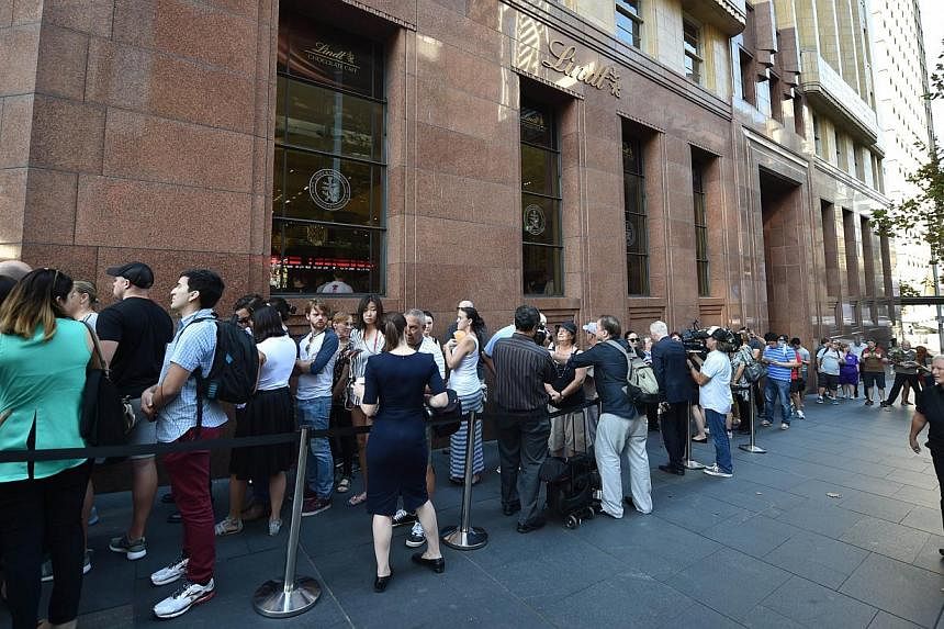 Members of the public queue outside the Lindt Cafe at Martin Place in Sydney ahead of the re-opening on March 20, 2015. Iranian-born Man Haron Monis took more than a dozen customers and staff hostage at the upmarket cafe on Dec 15, an incident which 