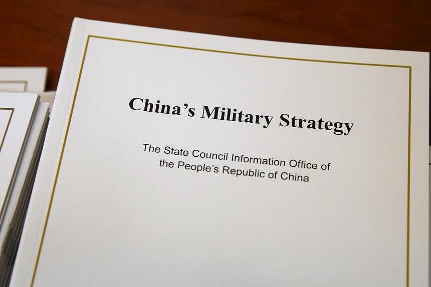 Copies of the annual white paper on China's military strategy are placed on a table for distribution to journalists during a news conference in Beijing, China, May 26, 2015. China outlined a defence strategy on Tuesday to boost its naval capability f