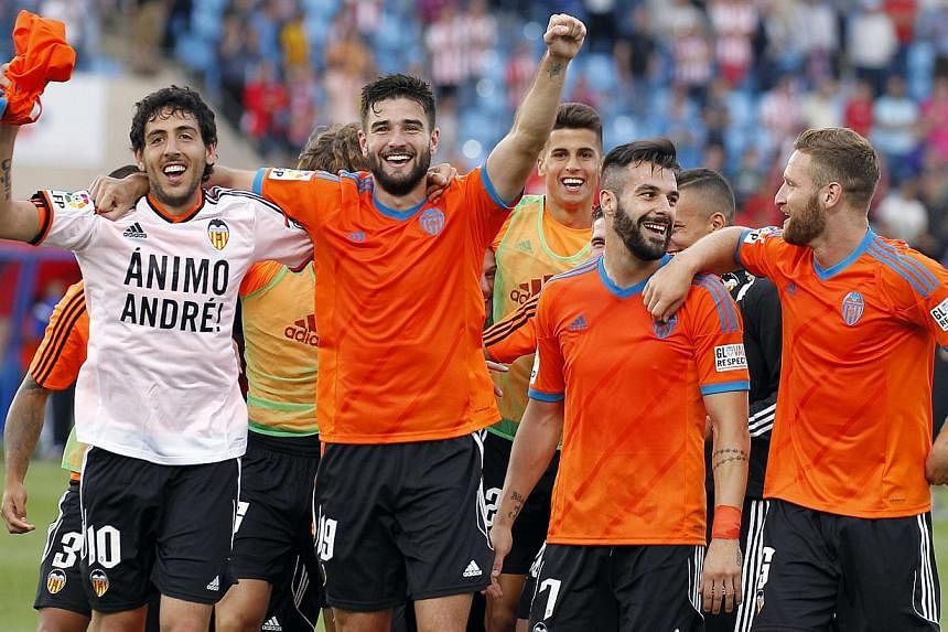 Valencia's players celebrate their qualification for the Champions League after the Spanish league football match between UD Almeria and Valencia CF at the Juegos Mediterraneos stadium in Almeria on May 23, 2015. The Spanish football club announced o