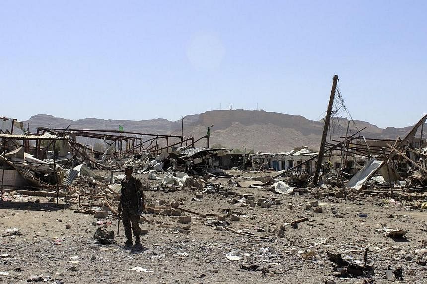 A Houthi militant stands by the ruins of a market that was destroyed by recent Saudi-led air strikes in Yemen's north-western city of Saada on May 24, 2015. -- PHOTO: REUTERS