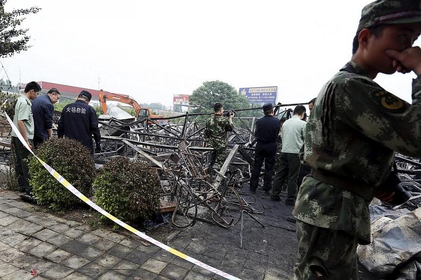 Policemen and fire inspectors work among the debris at a rehabilitation centre for elderly after a fire broke out on Monday, May 25, 2015,&nbsp;in Lushan county, Henan province, China, on Wednesday. -- PHOTO: REUTERS