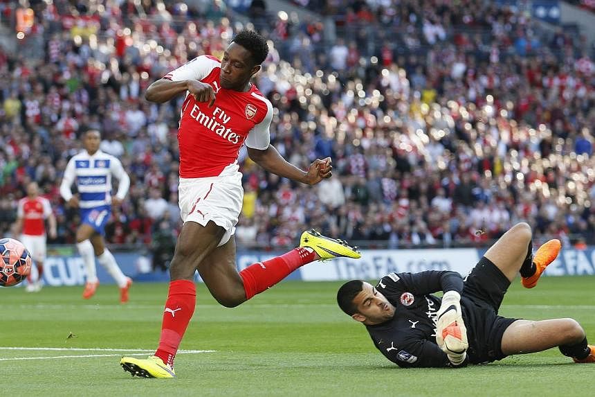 Arsenal's Danny Welbeck (left) pushes the ball past Reading keeper Adam Federici during the FA Cup Semi Final at Wembley Stadium on April 18, 2015. Arsenal manager Arsene Wenger has said that Welbeck will miss the team's FA Cup Final clash against As