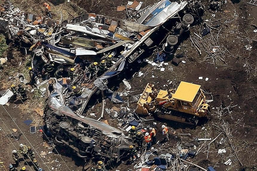 Investigators and first responders work near the wreckage of an Amtrak passenger train carrying more than 200 passengers from Washington, DC to New York that derailed late last night May 13 in north Philadelphia, Pennsylvania. At least five people we