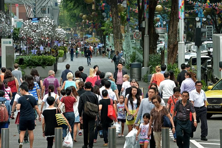 Shoppers along Orchard Road near the junction of Takashimaya. Consumer confidence in Singapore continued to climb in May, with respondents in a survey more upbeat about both their current and future financial state. -- PHOTO: ST FILE