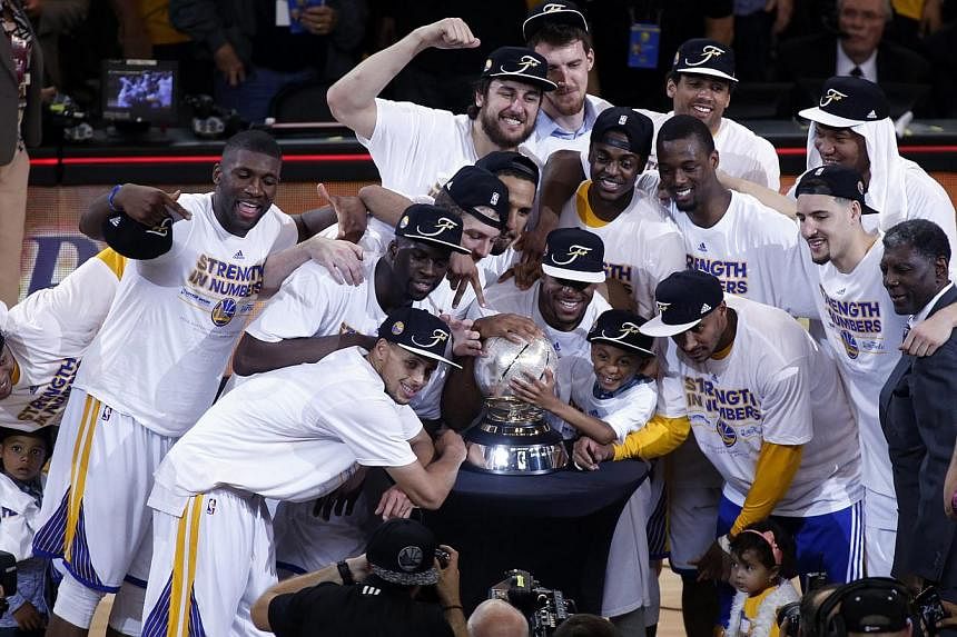 The Golden State Warriors pose for a photograph with the NBA Western Conference Finals trophy after defeating the Houston Rockets in Game five of the NBA Western Conference Finals at Oracle Arena in Oakland, California, USA, on May 27, 2015. -- PHOTO