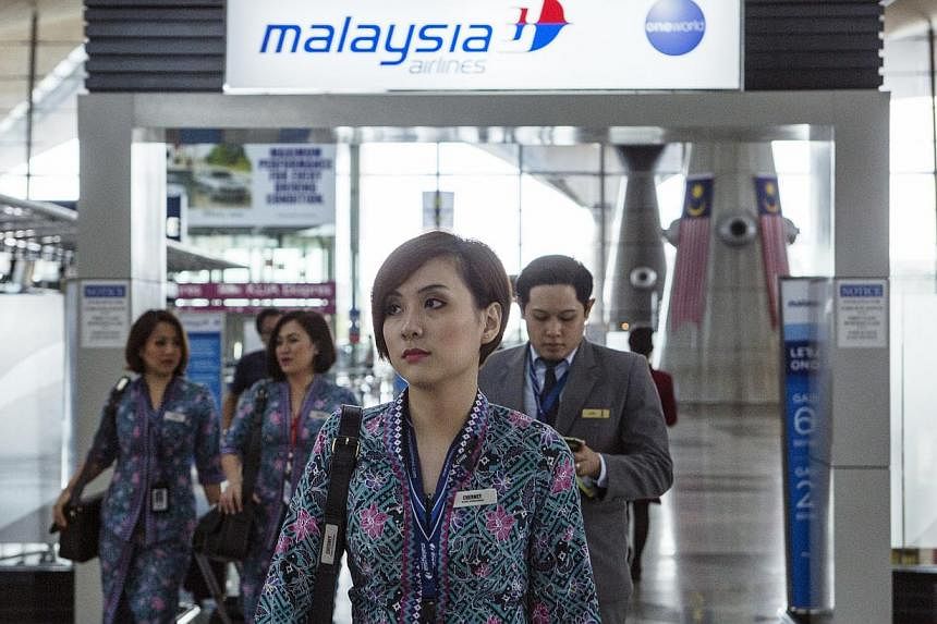 Malaysian Airline System Bhd. (MAS) air crew walk through Kuala Lumpur International Airport (KLIA) in Sepang, Malaysia, on Aug 26, 2014. -- PHOTO: BLOOMBERG